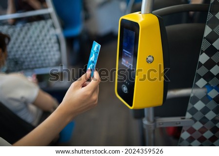 Asian woman hand paying conctactless with plastic card for the public transport in bus, tram or subway metro close up Royalty-Free Stock Photo #2024359526