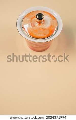 A top view of an orange covered cup on an orange isolated background with free space