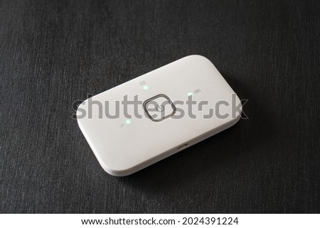 White pocket Wi-Fi hotspot device on black background. Royalty-Free Stock Photo #2024391224