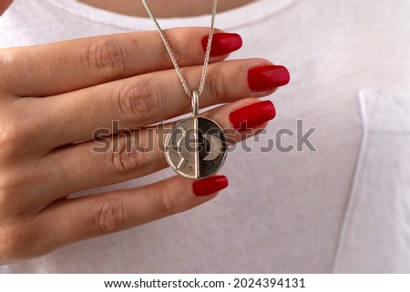 Women jewelry concept idea, woman  holding a silver necklace with a moon and sun motif. Beauty and accessories, Beautiful girl with stylish jewelry.