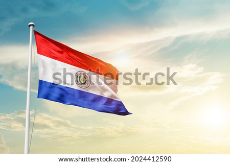 Paraguay national flag waving in beautiful clouds.