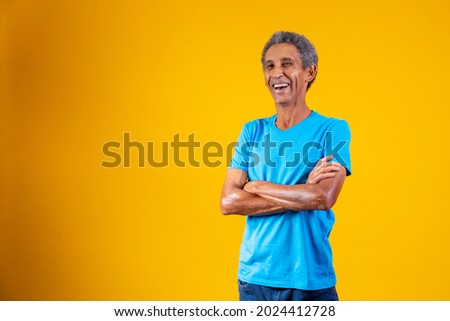 Portrait of afro elderly man with arms crossed smiling at the camera.