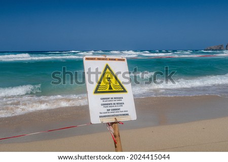 "Rip curl.You could be sweped away from shore".  Rip curl current danger sign on the beach of Cala Mezquida. Mallorca. Spain.