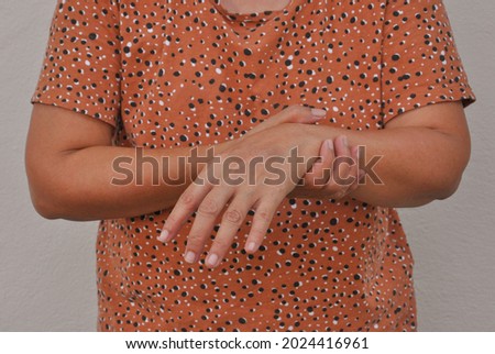 an old woman support her arms which pain,numbness,weakness,paralysis concept of Guillain barre syndrome caused by autoimmune disorder (selective focus)                          