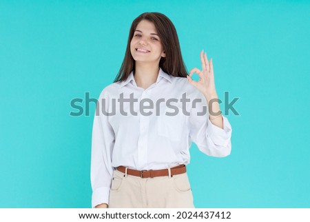 Woman with ok hand sign isolated on blue background
