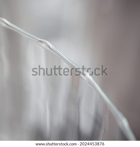 The wavy edge of a glass forms a graphic element in a square 
