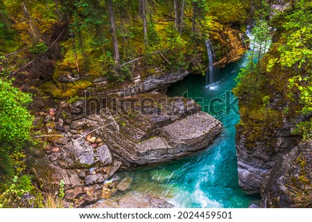 Waterfall in Maligne Canyon Alberta Canada in summer, beautiful forest, orange lichen ,green moss, Canadian woods, turquoise green glacial water Royalty-Free Stock Photo #2024459501