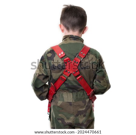 A back portrait of a Caucasian boy wearing camouflage clothes in a red leather holster, isolated on white background