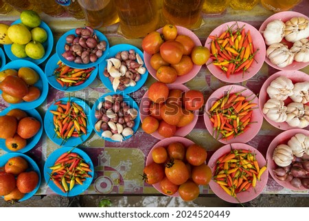 Tomatoes, peppers, garlic and onions, for sale at a food stall, in the local market in Waisai, Raja Ampat, Indonesia
