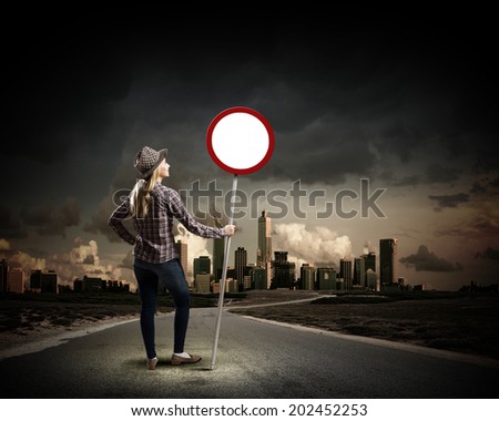 Young woman in casual holding road sign