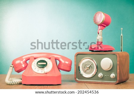 Retro rotary telephone, wooden radio and microphone front mint green background