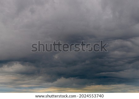Cloudy in sky before raining, A nimbostratus cloud is a multi-level, amorphous, nearly uniform and often dark grey cloud that usually produces continuous rain, snow or sleet, Horizon nature background Royalty-Free Stock Photo #2024553740