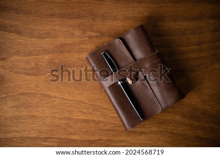 retro leather-covered blank sheet notebook on a wooden desk