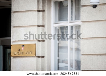 Sign indicating Hrvatski Sabor (Croatian parliament in croatia) on the main entrance in Zagreb. It is the parliament of Croatia, its unicameral legislature chamber since  the independence.

 Royalty-Free Stock Photo #2024569361