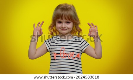 Keep calm down, relax, inner balance. Child kid girl breathes deeply with mudra gesture, eyes closed, meditating with concentrated thoughts, peaceful mind. Young children on yellow studio background.