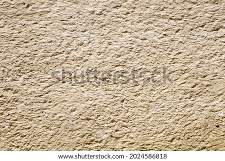 A closeup shot of a dark beige textured wall