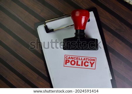 Red Handle Rubber Stamper and Cancellation Policy text isolated on wooden table. Royalty-Free Stock Photo #2024591414