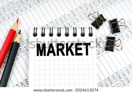 Economy and business concept. On the table are reports, pencils and a notebook with the inscription - MARKET