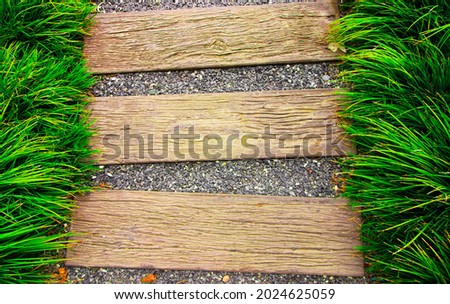 The background photograph features grass, planks, and small stones.