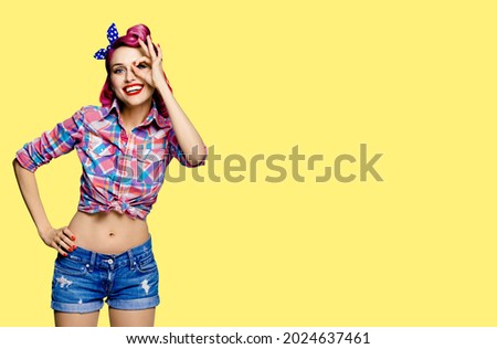 Pin up girl. Excited happy red purple haired woman showing ok sign gesture, looking throw her hand. Retro vintage and sales ad concept. Yellow color background with copy space mock up free area. 