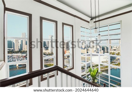 The stairwell of an upscale loft condo unit with views of Miami skyline. Interior of a luxury real estate property in South Florida.