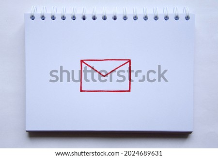 Photo of a drawing of red letter on white paper of notebook