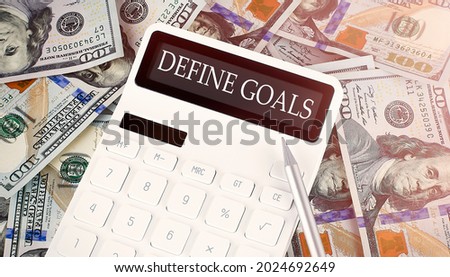 DEFINE GOALS text on display calculator on the dollars background