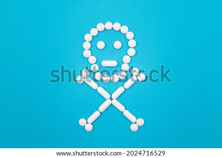 Dangerous Pharmaceutical Products or Unsafe Pills and Tablets - Skull or Death Symbol Made from White Pills Lying on Blue Background Royalty-Free Stock Photo #2024716529