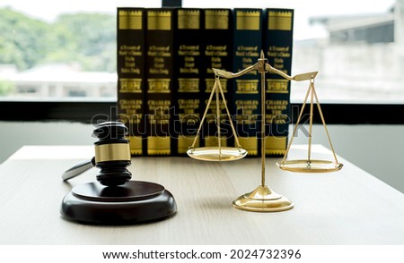 The judge's gavel at the law firm has scales, scales of justice, and litigation documents. Concepts of law and justice.