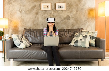 Young asian woman is using virtual reality headset.Concept of virtual reality, simulation, gaming and future technology.Asian woman play game in living room apartment.