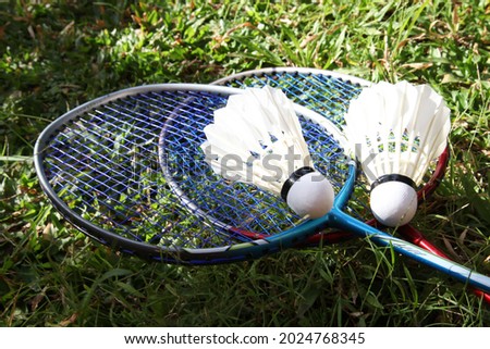 Badminton rackets with shuttlecocks on field