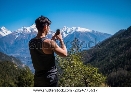 Young man taking photo with cell phone