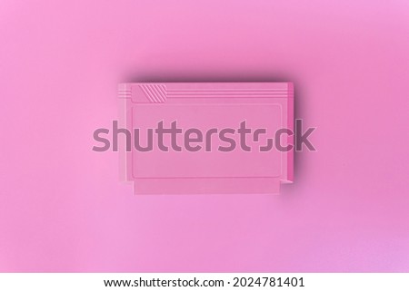 Pink 8 bit game cartridge  for retro game console on pink background. Minimal concept.