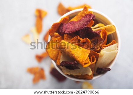 Vegetable organic chips made from potatoes, beets and carrots in a white glass for a snack, top view Royalty-Free Stock Photo #2024790866