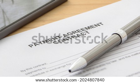 A payment agreement contract form on the desk. Pen on the table

