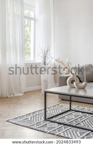 Room interior with sofa, modern apartment design. Couch furniture at home, minimal stylish living room of cozy flat. Vertical shot of simple loft coffee table near window. Royalty-Free Stock Photo #2024833493