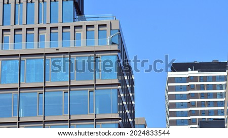 View of office building with glass wall under blue sky. Architecture details of business background.