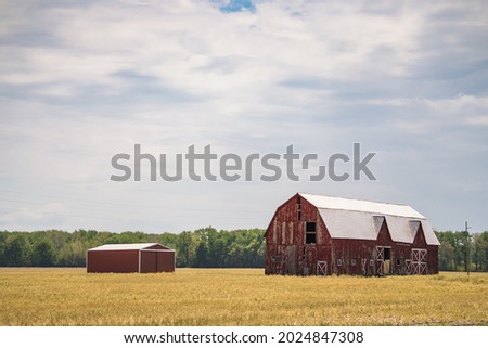 Old abandoned red barn in field	