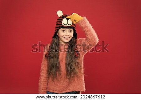 Playful tiger. Festive spirit. Cheerful smiling kid. Playful cutie. Children seems cute. Adorable baby wear cute winter knitted hat. Cute accessories. Girl wear winter theme accessory. Fun and joy
