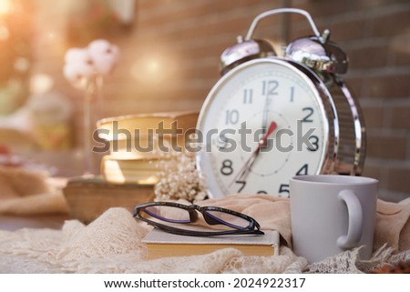 Startup concept. Cup of coffee, alarm clock, books, glasses. Start your day with morning coffee. Education business place, vintage tone
