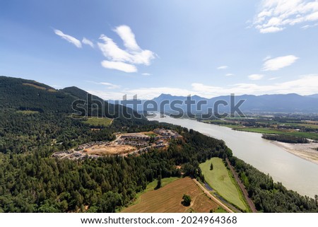 Aerial View of Fraser Valley with Canadian Nature Mountain Landscape Background. Harrison Mills near Chilliwack, British Columbia, Canada. Royalty-Free Stock Photo #2024964368