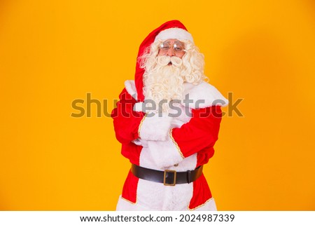 Santa Claus with crossed arms on yellow background.