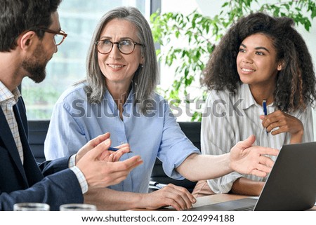 Happy diverse business people group negotiating business strategy at boardroom meeting table using laptop. Multicultural team discuss project developing financial research working together in office. Royalty-Free Stock Photo #2024994188