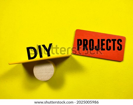 Text DIY PROJECTS writing on colored wooden board on a yellow background. Trending photos concept.