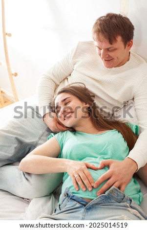 young caucasian pregnant couple together at home relaxing in bed, lifestyle people concept