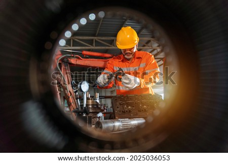 An excavator repair technician use vernier caliper and holding bulldozer sprocket to inspection and repair maintenance heavy machinery, Industrial Theme. Royalty-Free Stock Photo #2025036053
