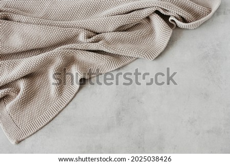 Beige knitted blanket on gray concrete background with copy space.Autumn, winter  concept.Flat lay, top view Royalty-Free Stock Photo #2025038426