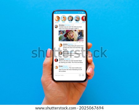 Person holding phone in hand with sample social media news feed on the screen Royalty-Free Stock Photo #2025067694