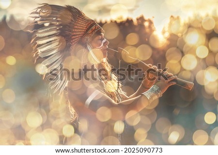 beautiful shamanic girl playing on shaman flute in the nature.