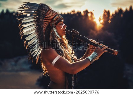 beautiful shamanic girl playing on shaman flute in the nature. Royalty-Free Stock Photo #2025090776